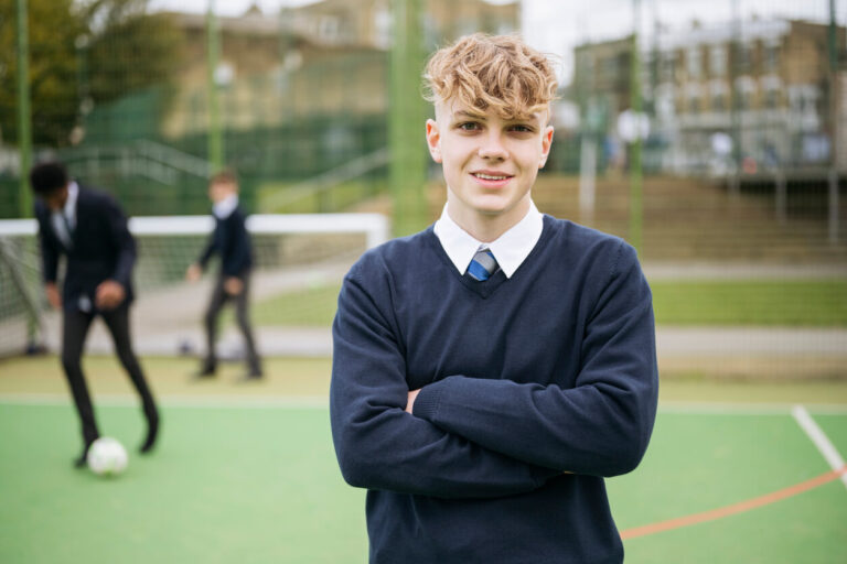 Boy with folded arms in school playground
